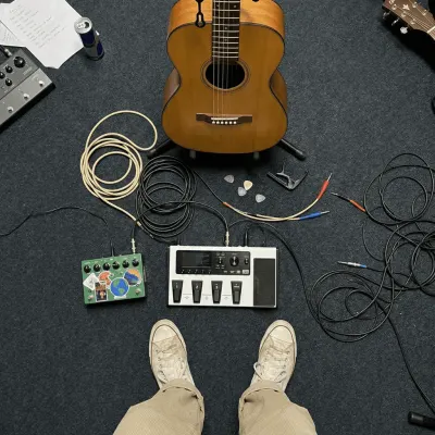 Acoustic guitar, pedals, and cables set up to record a music demo
