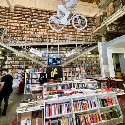 Bookshop interior with full shelves and a bicycle suspended from the ceiling