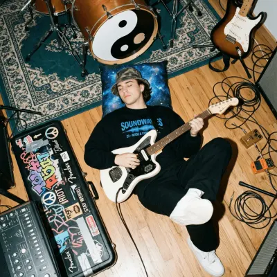 Guitarist lying among instruments and equipment in a rehearsal room