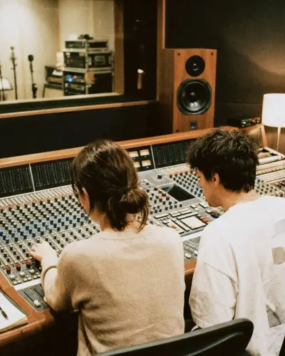 Two people working at the mixing console in a recording studio